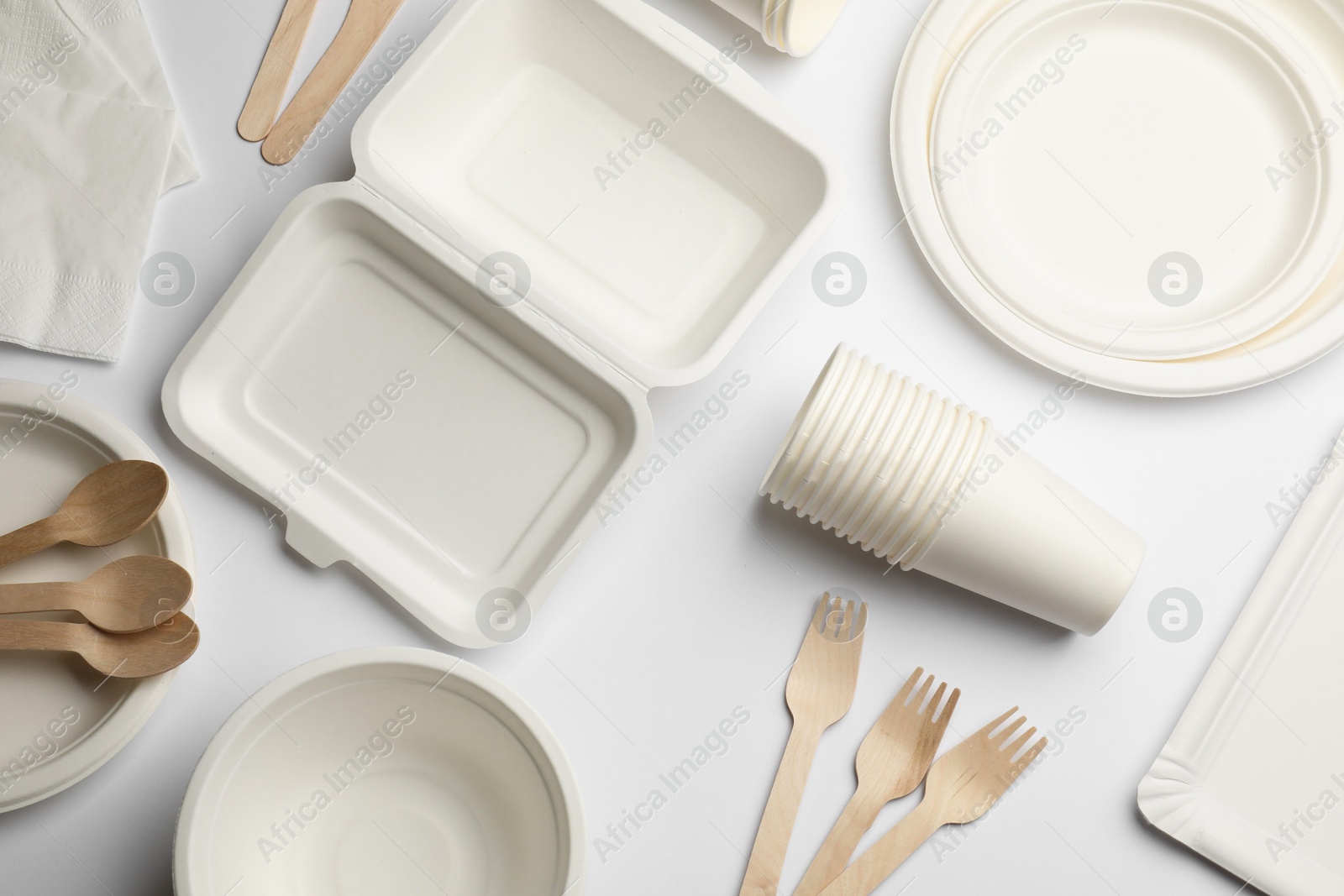 Photo of Set of disposable tableware and napkins on white background, flat lay