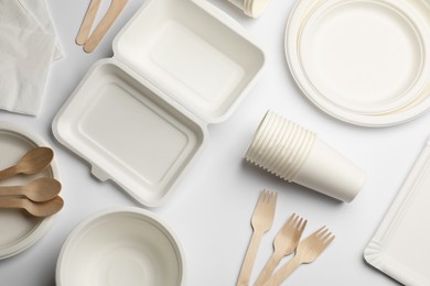 Photo of Set of disposable tableware and napkins on white background, flat lay