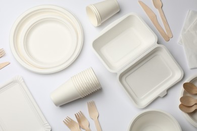 Photo of Set of disposable tableware and napkins on white background, flat lay