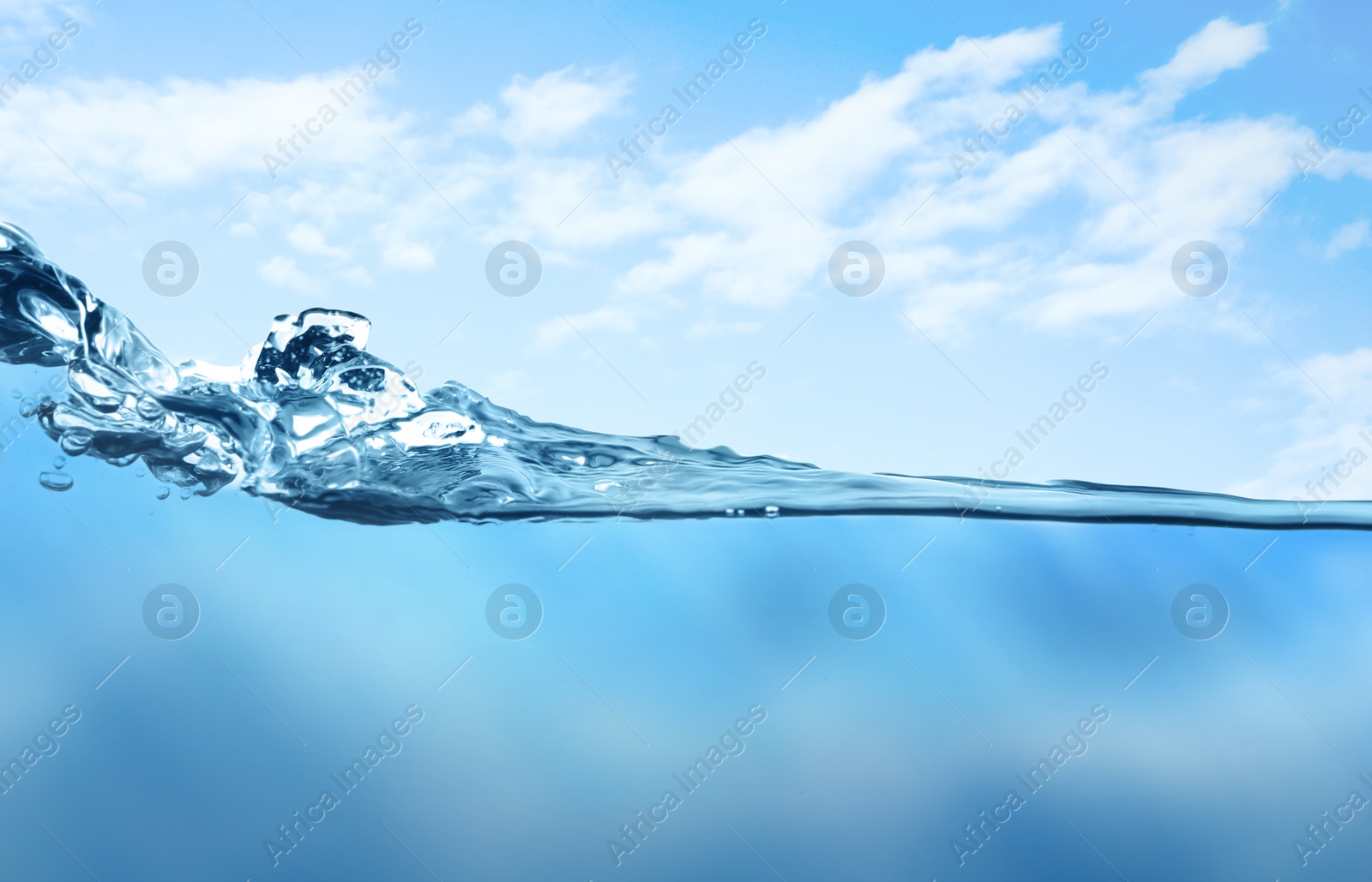 Image of Sea water surface and underwater view. Sky with clouds above