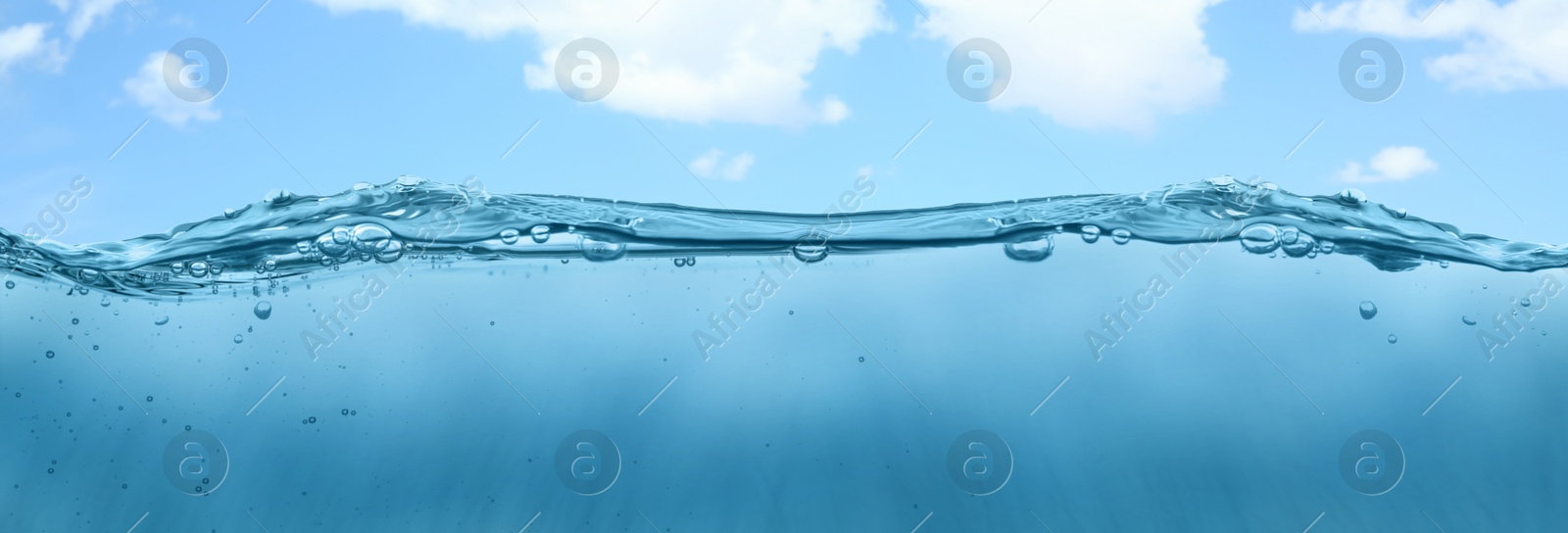 Image of Sea water surface and underwater view. Sky with clouds above