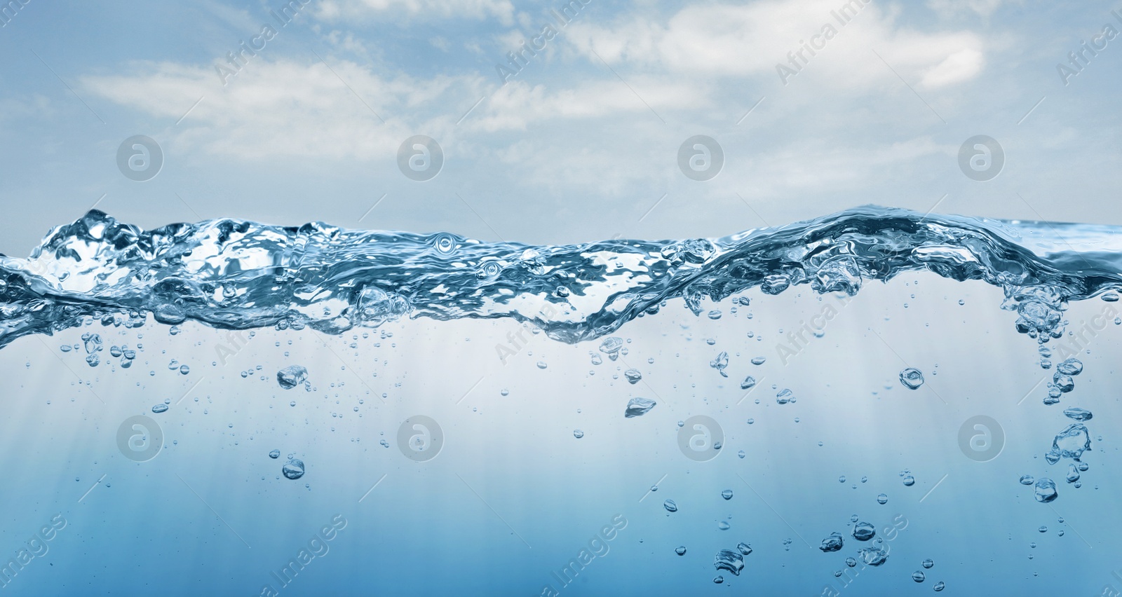 Image of Sea water surface and underwater view. Sky with clouds above