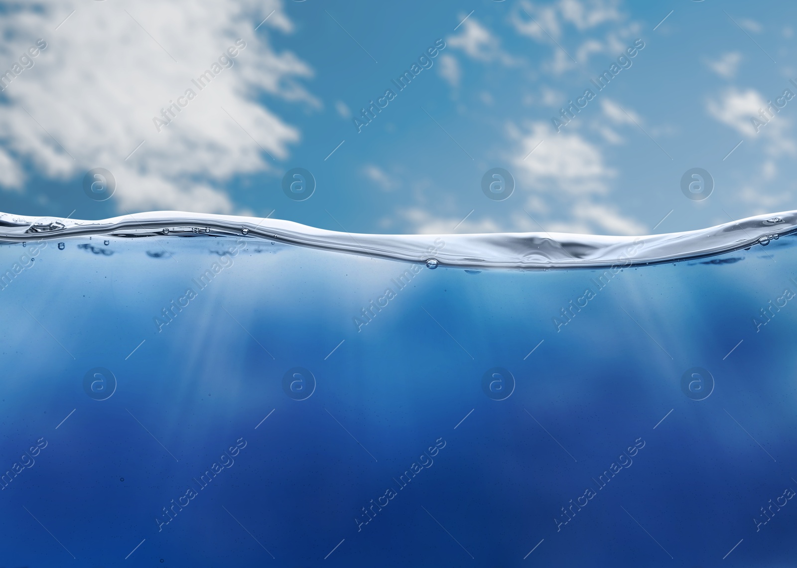 Image of Sea water surface and underwater view. Sky with clouds above