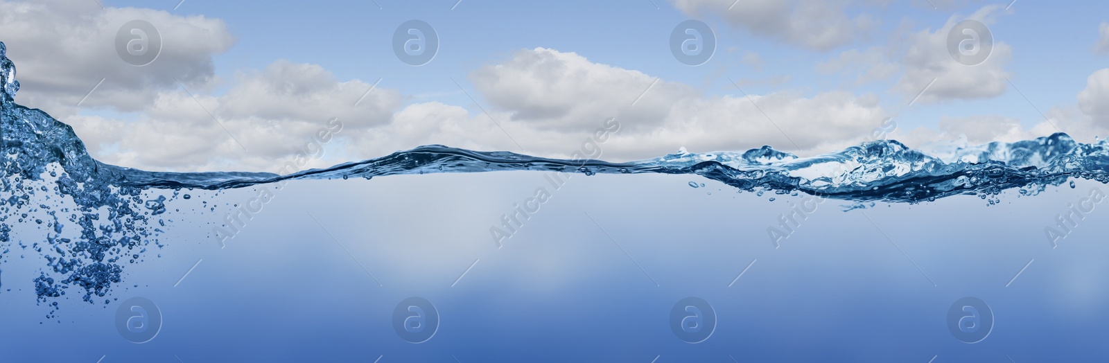 Image of Sea water surface and underwater view. Sky with clouds above