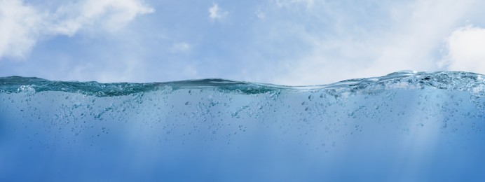 Image of Sea water surface and underwater view. Sky with clouds above