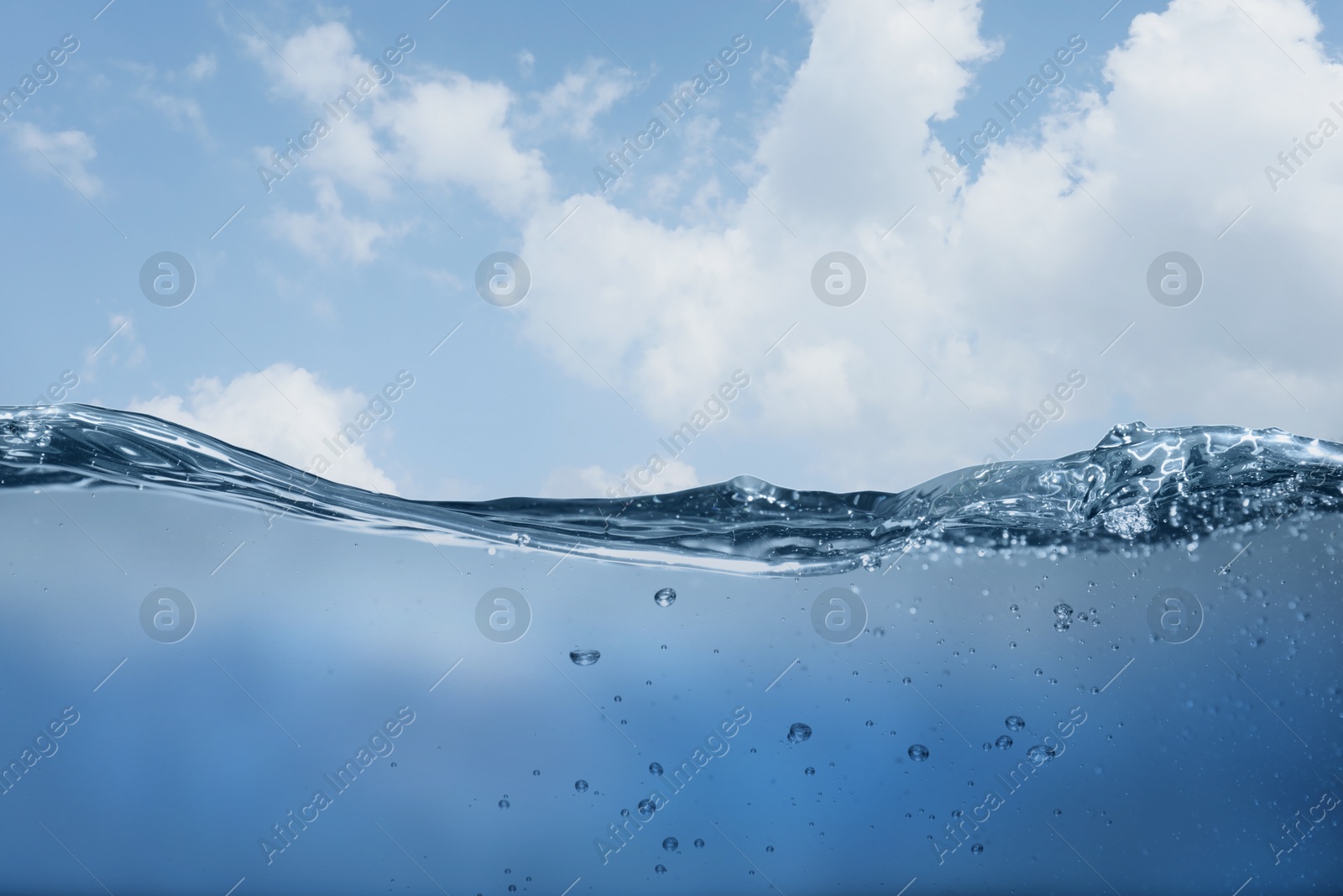 Image of Sea water surface and underwater view. Sky with clouds above