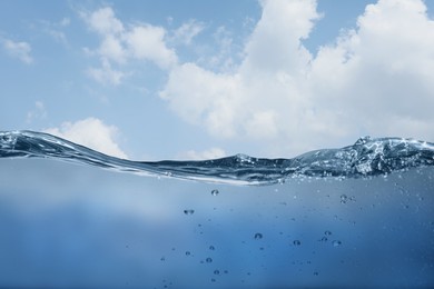 Image of Sea water surface and underwater view. Sky with clouds above