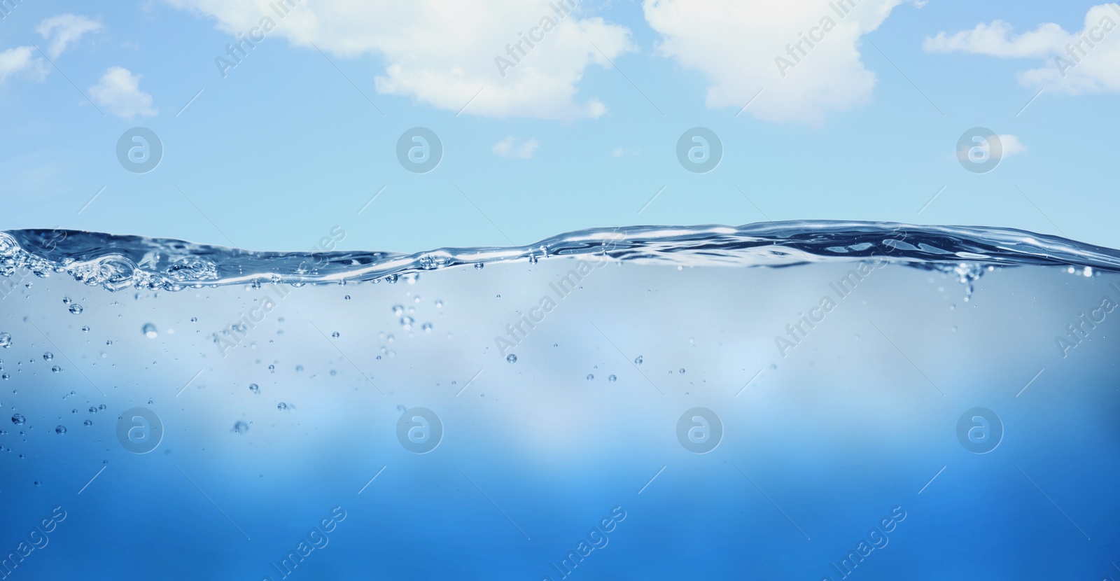 Image of Sea water surface and underwater view. Sky with clouds above