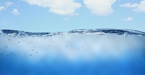Image of Sea water surface and underwater view. Sky with clouds above