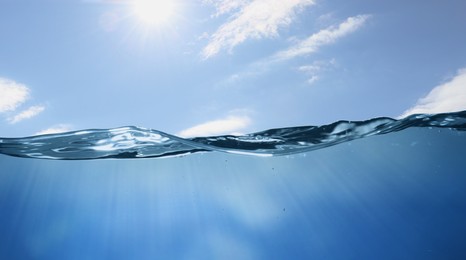 Image of Sea water surface and underwater view. Sky with clouds above