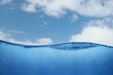 Image of Sea water surface and underwater view. Sky with clouds above