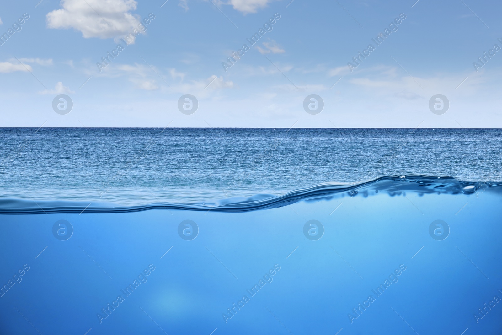 Image of Sea water surface and underwater view. Sky with clouds above