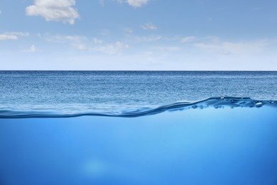 Image of Sea water surface and underwater view. Sky with clouds above