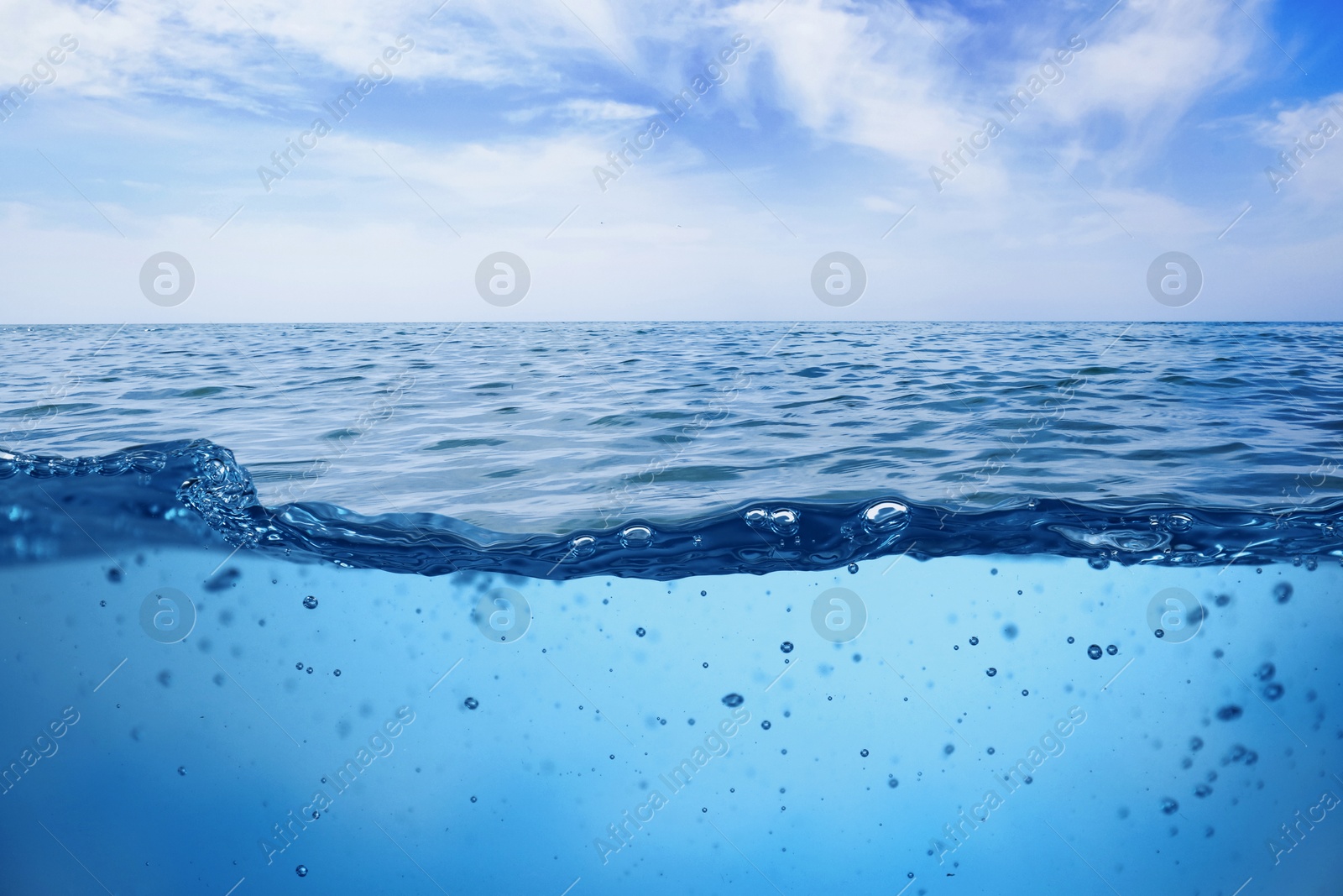 Image of Sea water surface and underwater view. Sky with clouds above