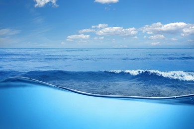 Image of Sea water surface and underwater view. Sky with clouds above