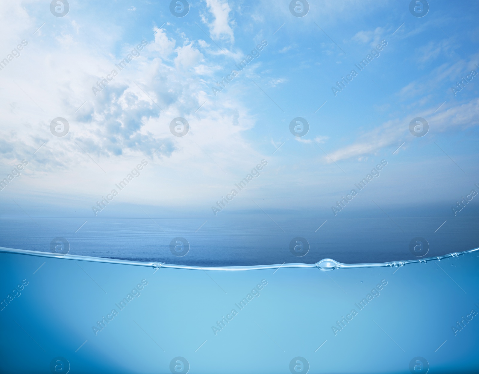 Image of Sea water surface and underwater view. Sky with clouds above