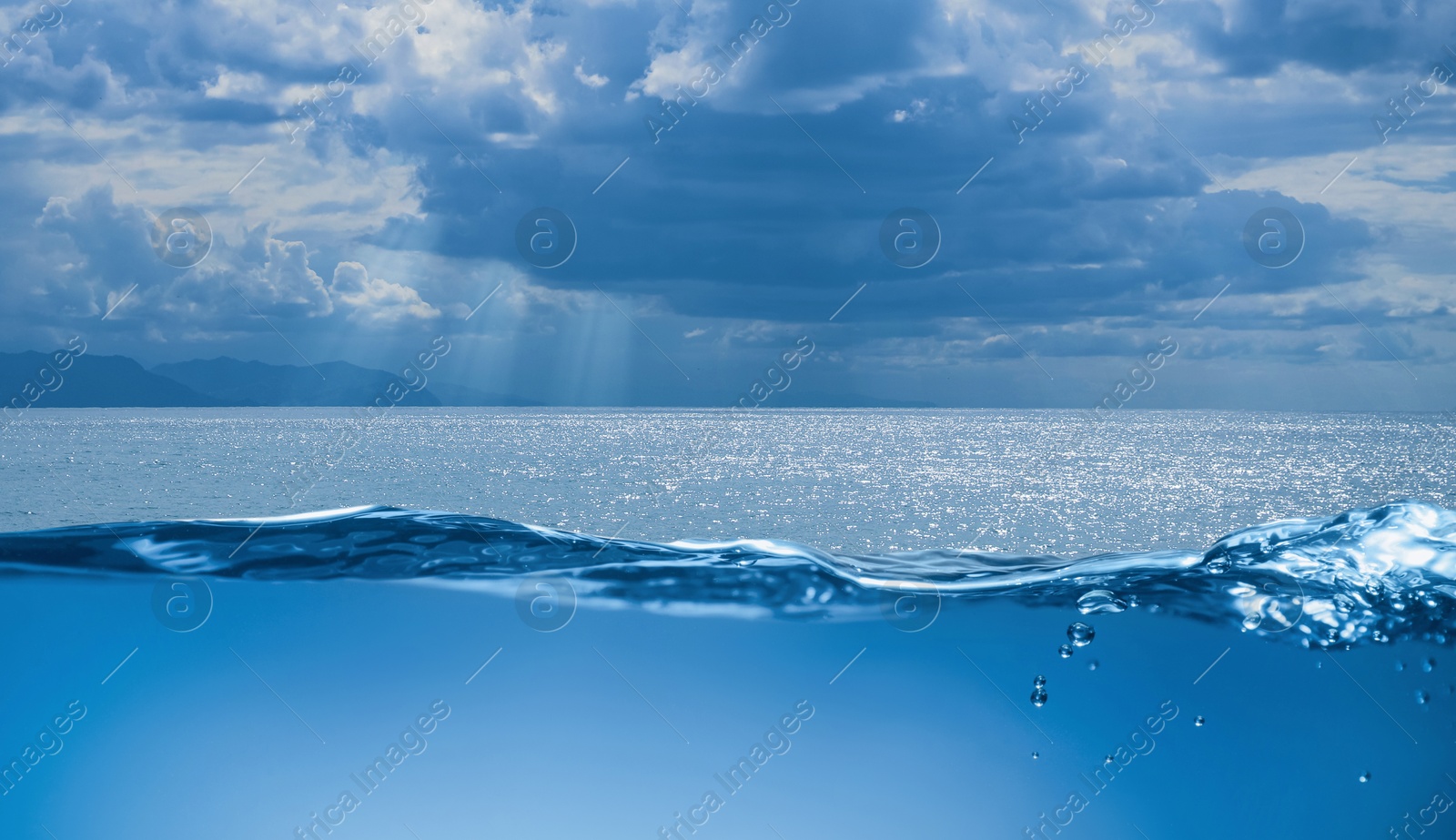 Image of Sea water surface and underwater view. Sky with clouds above