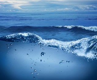 Image of Sea water surface and underwater view. Sky with clouds above