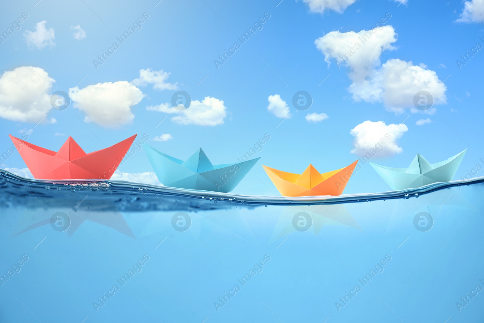 Image of Paper boats on sea water surface and underwater view. Sky with clouds above