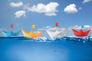 Image of Paper boats on sea water surface and underwater view. Sky with clouds above
