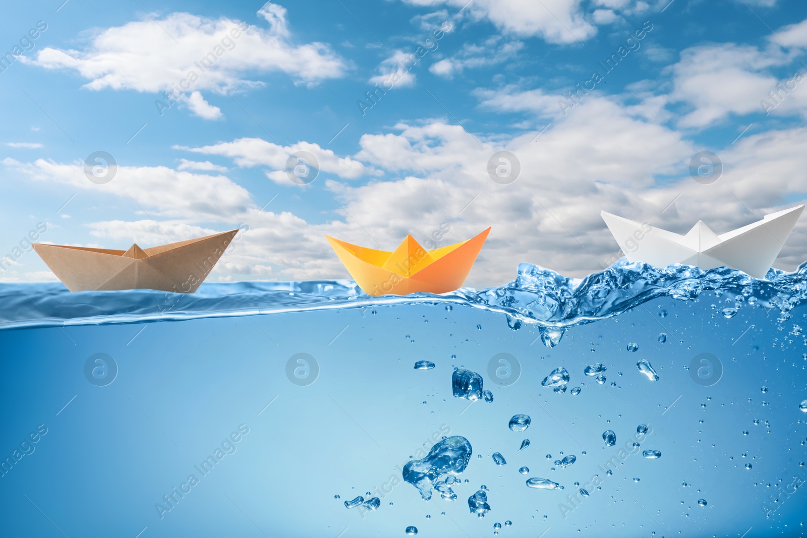 Image of Paper boats on sea water surface and underwater view. Sky with clouds above