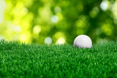 Image of Golf ball on green grass against blurred background