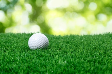 Image of Golf ball on green grass against blurred background