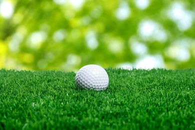 Image of Golf ball on green grass against blurred background