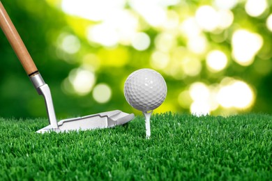 Image of Golf ball, tee, club and green grass against blurred background