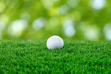 Image of Golf ball on green grass against blurred background
