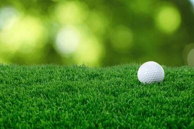 Image of Golf ball on green grass against blurred background