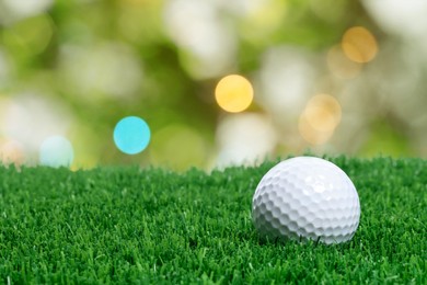 Image of Golf ball on green grass against blurred background