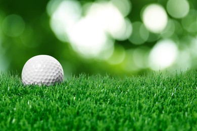 Image of Golf ball on green grass against blurred background