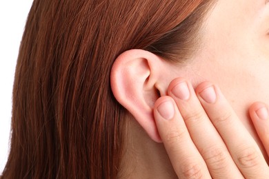Photo of Sound. Woman touching her ear on white background, closeup