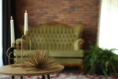 Photo of Coffee table with decor, vintage sofa and houseplant in room, selective focus