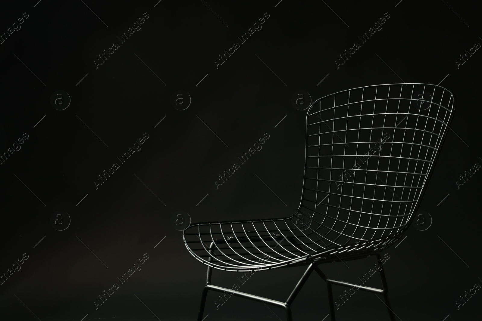 Photo of Stylish chair on black background, space for text. Used stuff