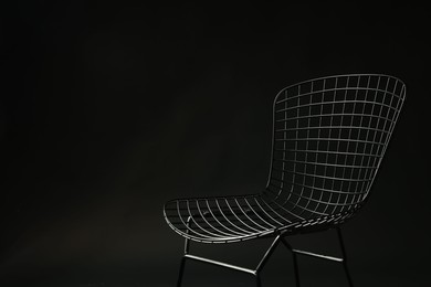 Photo of Stylish chair on black background, space for text. Used stuff