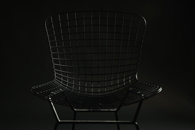 Photo of Stylish chair on black background, closeup. Used stuff