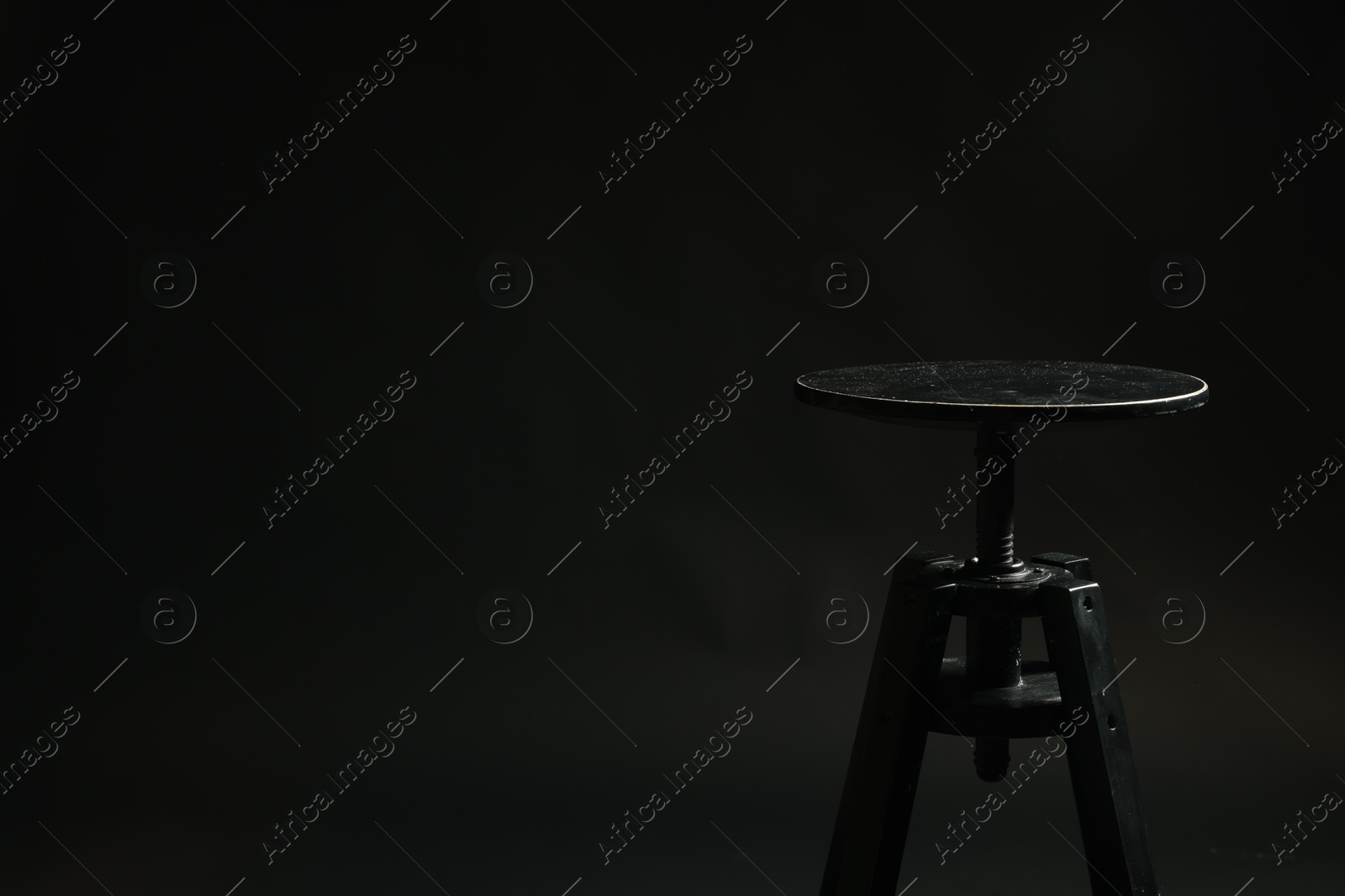 Photo of Bar stool on black background, space for text. Used stuff