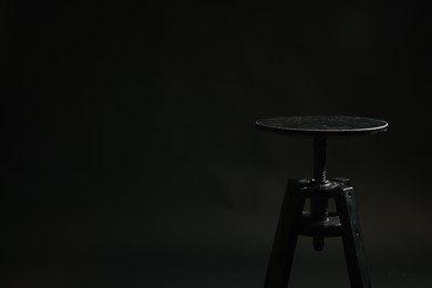 Photo of Bar stool on black background, space for text. Used stuff
