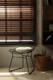 Photo of Stylish chair and other used stuff near window indoors