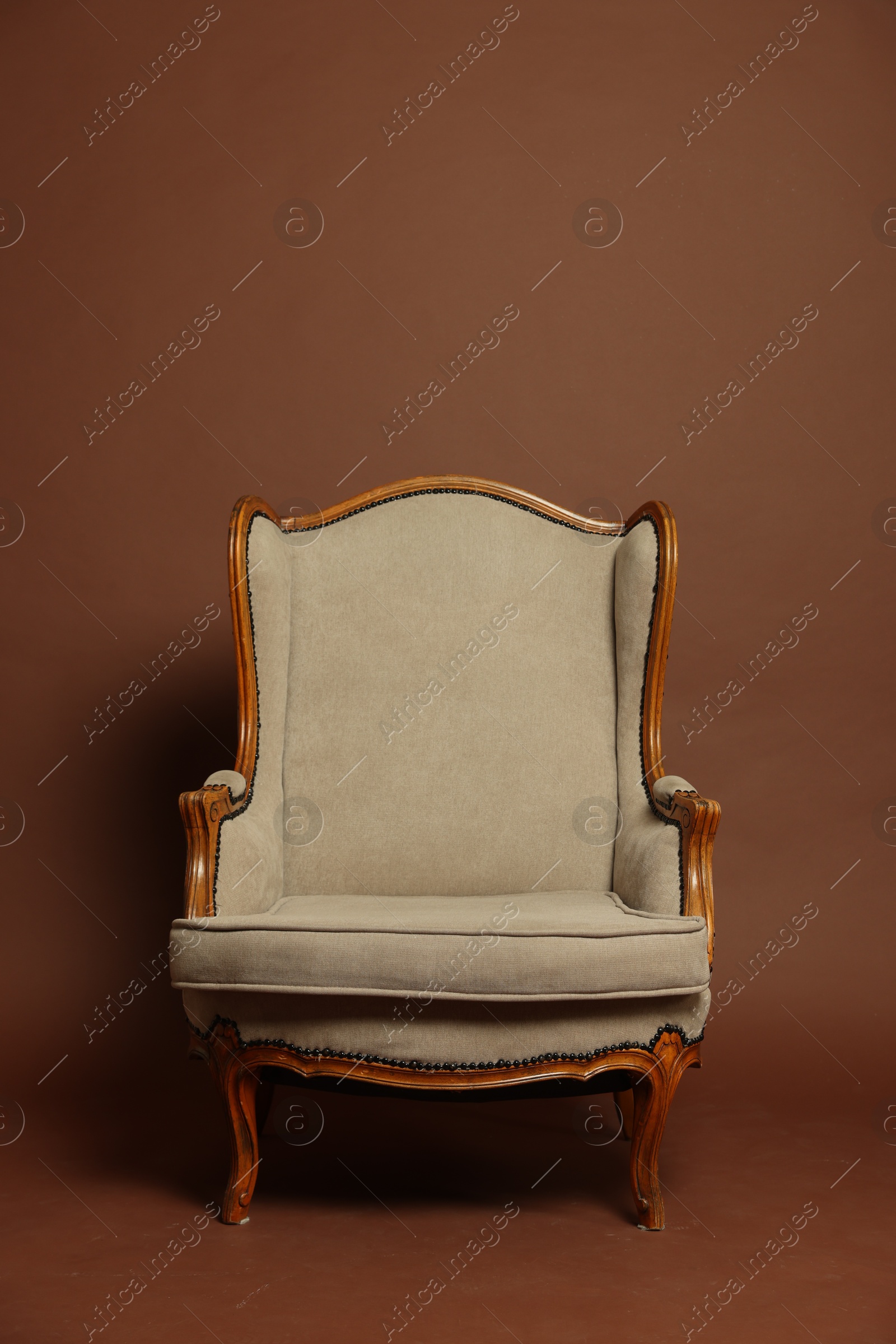 Photo of Stylish armchair on brown background. Used stuff