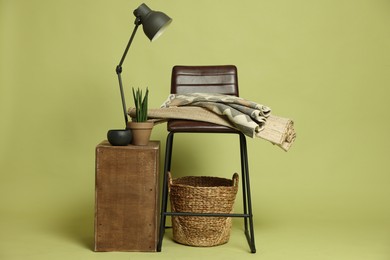 Photo of Stylish bar stool and other used stuff on olive background