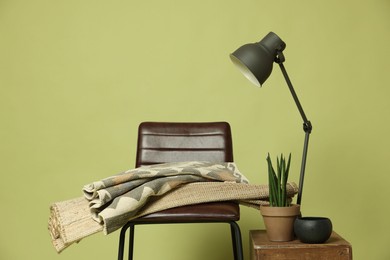 Photo of Stylish bar stool and other used stuff on olive background