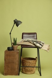Photo of Stylish bar stool and other used stuff on olive background