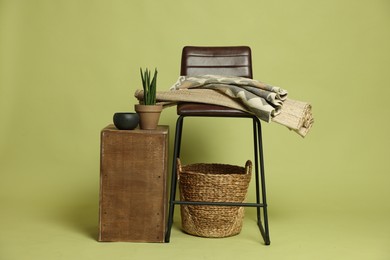 Photo of Stylish bar stool and other used stuff on olive background