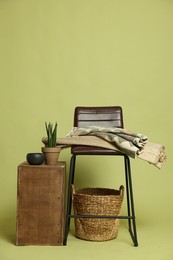Photo of Stylish bar stool and other used stuff on olive background