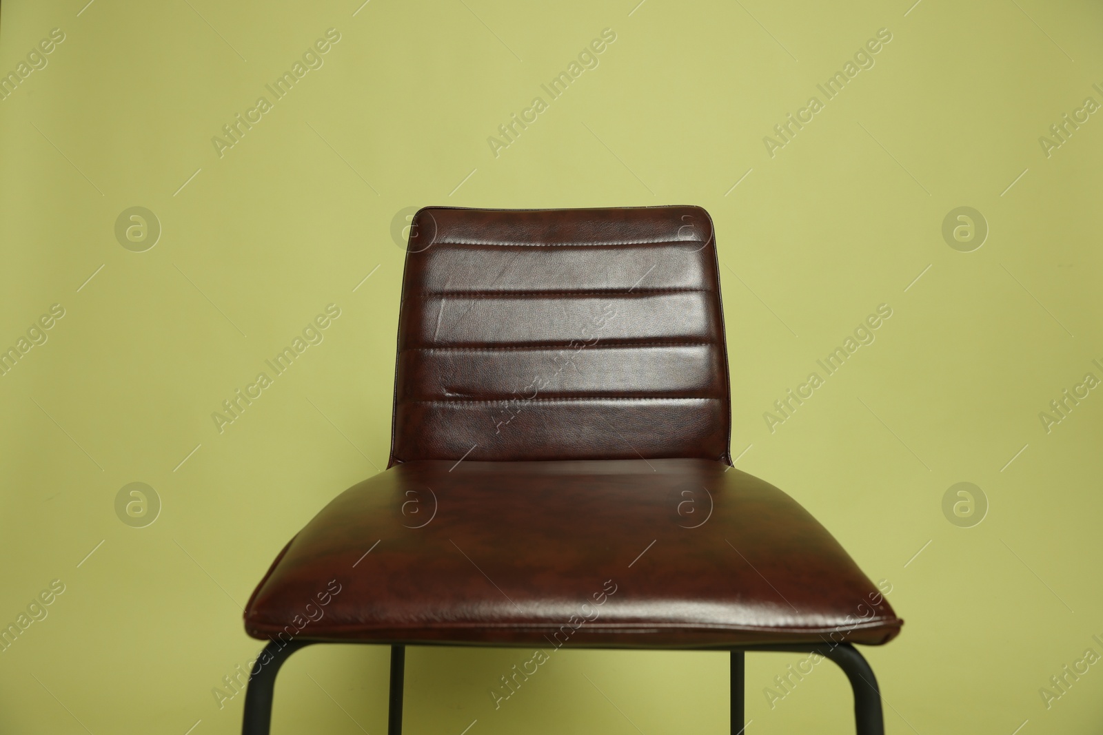 One bar stool on olive background, closeup. Used stuff Photo of One bar stool on olive background, closeup. Used stuff