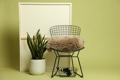 Photo of Stylish chair and other used stuff on olive background