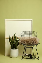 Photo of Stylish chair and other used stuff on olive background